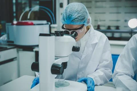 Female researcher observing samples with microscope in modern medical biolo.. Stock Photos