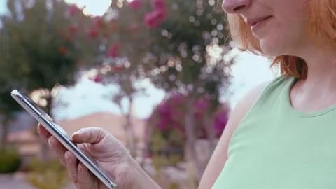 Female in Residential Cottage Community Using Smartphone Outdoors for Searching Stock Footage 329930232