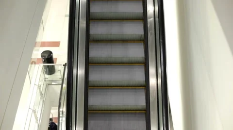 Female riding down escalator Stockbeeldmateriaal 1138865