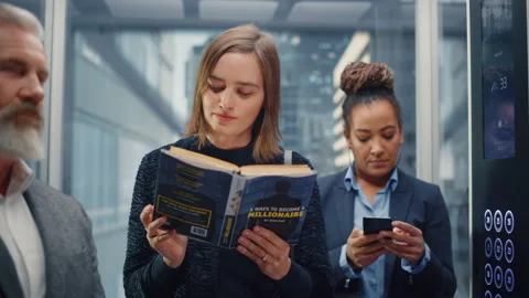 Female Riding Elevator Reading Book 스톡 동영상 167837155