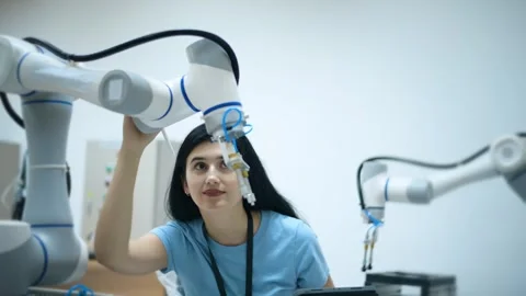 Female Robotics engineer working with Programming and Manipulating Robot Hand Stock Footage 280789795