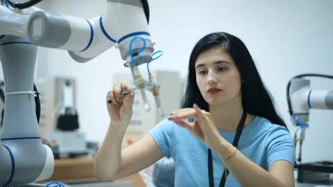 Female Robotics engineer working with Programming and Manipulating Robot Hand Stock Footage 280790008