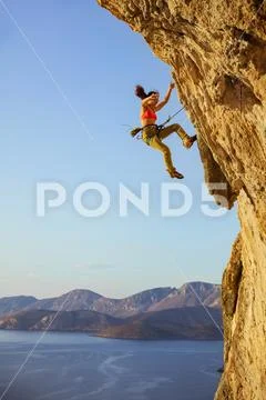 Female rock climber falling off cliff while lead climbing Stock Photos