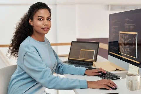 Female rogrammer working on computer in modern office of IT company Stock Photos