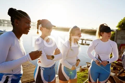 Female rowing team standing at sunny lakeside Stock Photos