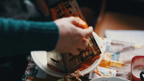 Female rubs carrots at a grater on a chopping board Stock Footage