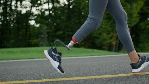 Female runner with artificial limb exercising in park.Girl legs running outdoors Stock Footage 125520151
