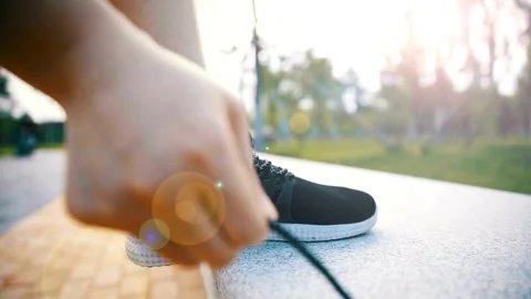 Female runner getting ready for jogging outdoors in sunny day. Woman Tying .. Stock Footage 265939338