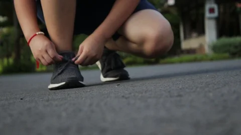 Female runner getting ready tying running shoes. Видео 107254196