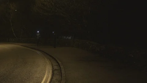 Female runner with head torch jogging on sidewalk at night Stock Footage 113005672
