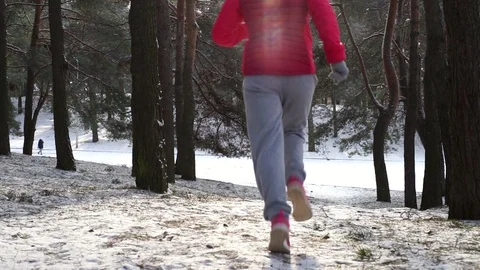 Female runner jogging in cold winter forest wearing warm sporty running clothing Vídeos de archivo 91186014