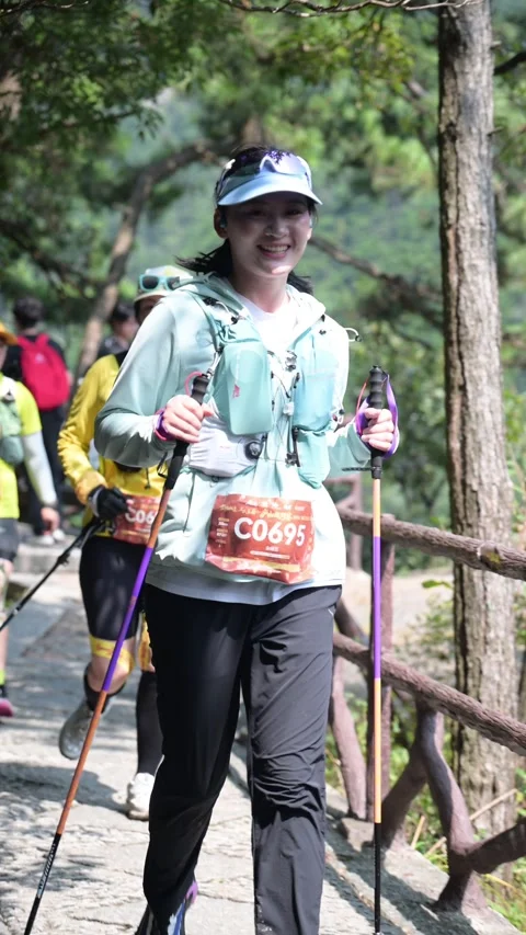 Female Runner in Light Blue Jacket with Poles on Stone Trail, Lushan Stock Footage 346716811