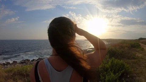 Female runner looking at the sun setting behind the coastline Stock Footage 114626520
