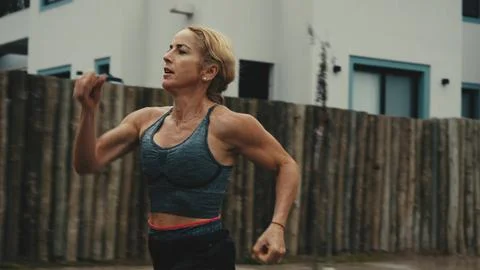 Female runner mid-stride with intense focus outdoors Foto stock