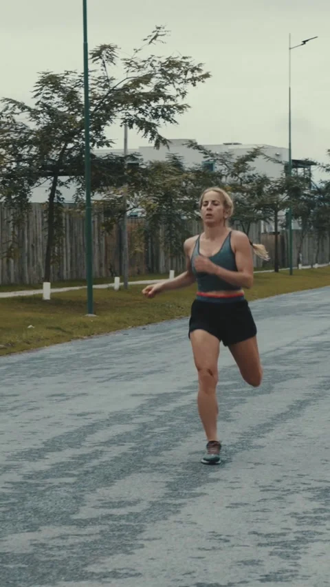 Female runner pauses to catch her breath then resumes running Stock Footage 340046913