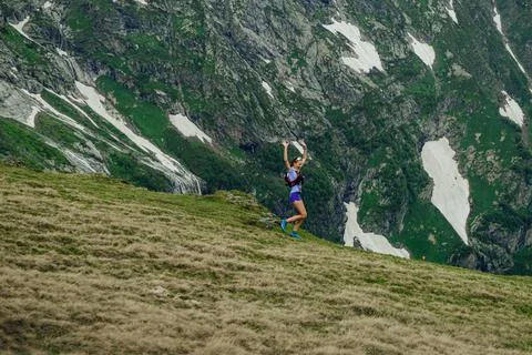 Female runner run trail down mountain Stock Photos