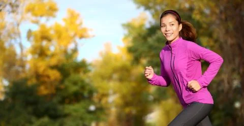 Female runner running in fall forest outside - Woman jogging Stock Photos