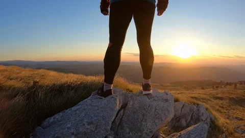 Female runner standing on a rock on the top of the mountain. Stock Footage 95780452