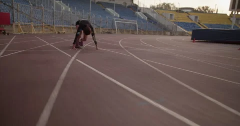 Female runner at starting block getting ready before run Stock Footage 243625625