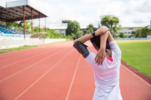 The female runner is warming up before jogging in the field. Stock Photos