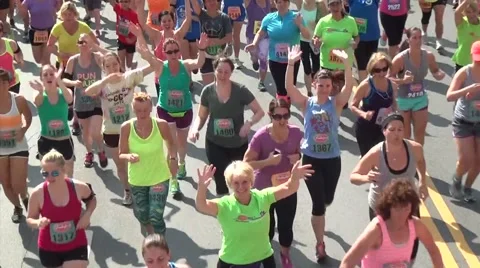 Female runners cheer going by camera Video stock 50940870