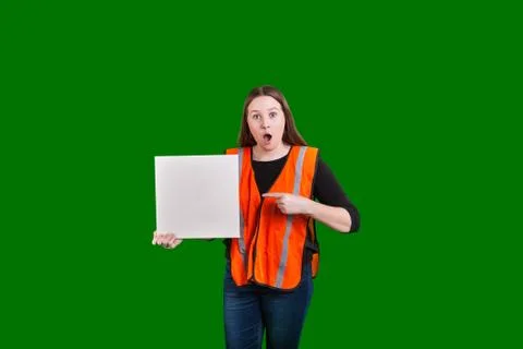 Female saftey worker pointing at blank sign ith surprised expression Stock Photos