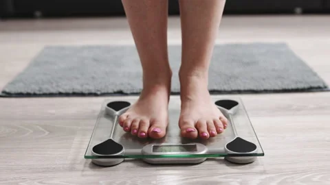 Woman standing on fitness scale, Stock Video