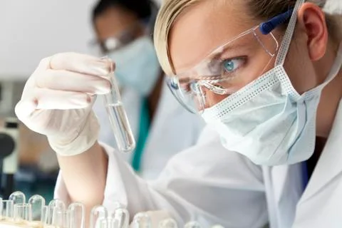 Female scientific research team with clear solution in laboratory Stock Photos