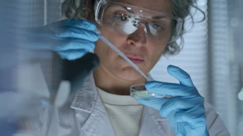 Female Scientist Adding Liquid to Plant Sample in Petri Dish with Pipette Stock Footage 291264300