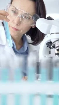 Female scientist analyzing sample in laboratory. Focused woman researcher 스톡 사진