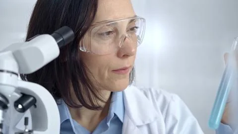 Female scientist analyzing sample of a test tub in laboratory setting. Science Stock-Fotos