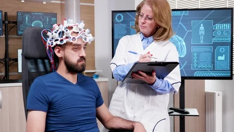 Female scientist in brain activity taking notes on her clipboard Video stock 119690660