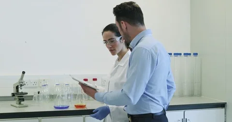 Female scientist discussing data with pharmaceutical sales rep Stock Footage 74767477