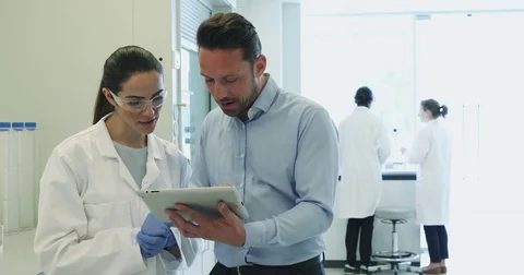Female scientist discussing data with pharmaceutical sales rep Stock Footage 74772876