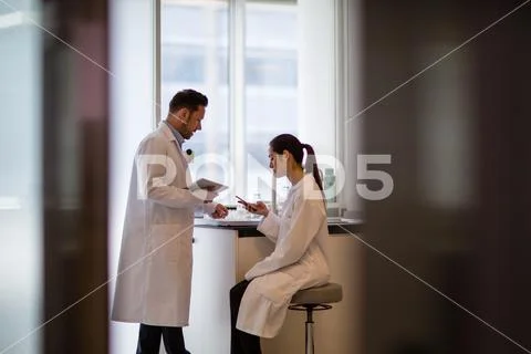 Female scientist discussing results of experiment with male colleague Stock Photos