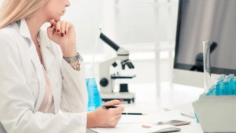 Female scientist examines the data on the computer Stock Photos