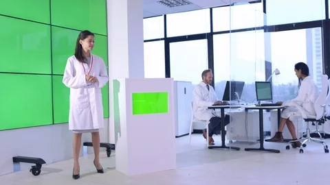 Female scientist explaining in front of green screen display in office Stock Footage 108177831