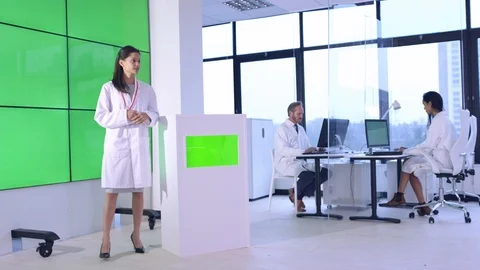 Female scientist explaining in front of green screen display in office Stock Footage 108178537