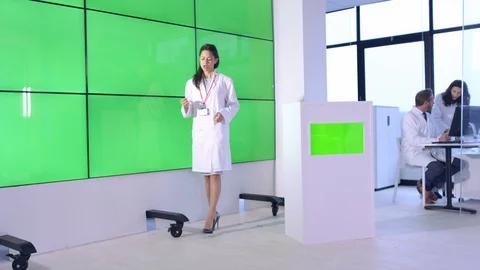Female scientist explaining in front of green screen display in office Stock Footage 108178544