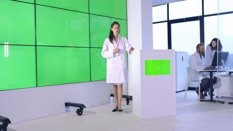 Female scientist explaining in front of green screen display in office Stock Footage 108178967