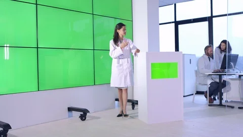 Female scientist explaining in front of green screen display in office Stock Footage 108179769