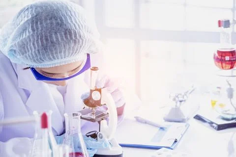 Female scientist look at microscope, science test tube analyse scientific s.. Stock Photos