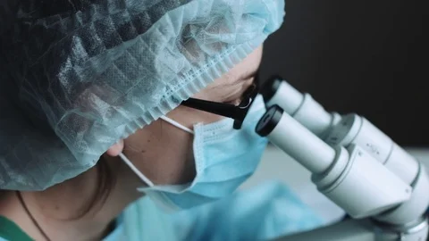 Female scientist looking through microscope Stock Footage 70152590