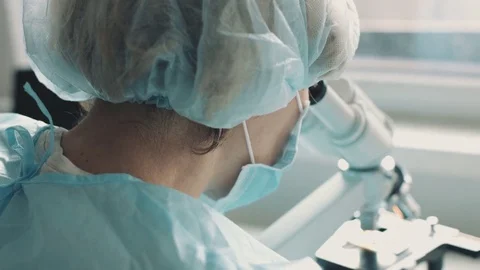 Female scientist looking through microscope 스톡 동영상 71142180