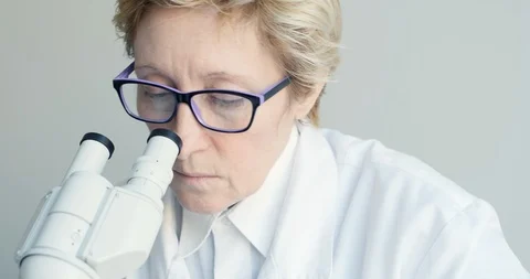 Female scientist looking through microscope 스톡 동영상 87483841