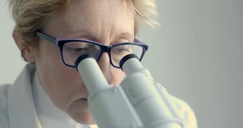 Female scientist looking through microscope 스톡 동영상 87484649