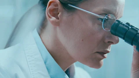 Female Scientist Looking through Microscope Eyepiece during Lab Research Stock Footage 331353945