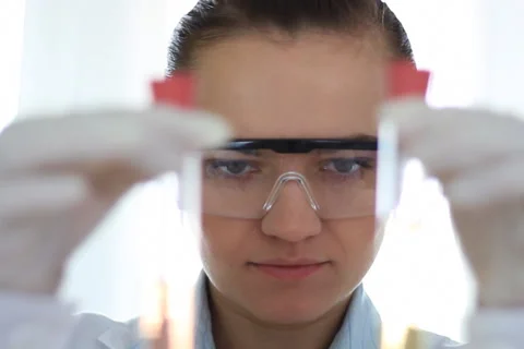 Female scientist looking at two test tubes NTSC Stock Footage 5089829