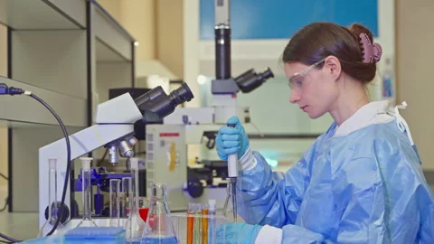 Female scientist pipetting a solution into a test tube in a laboratory Video stock 346939584