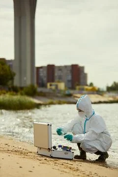 Female Scientist in Protective Suit Testing River Water Pollution Stock Photos